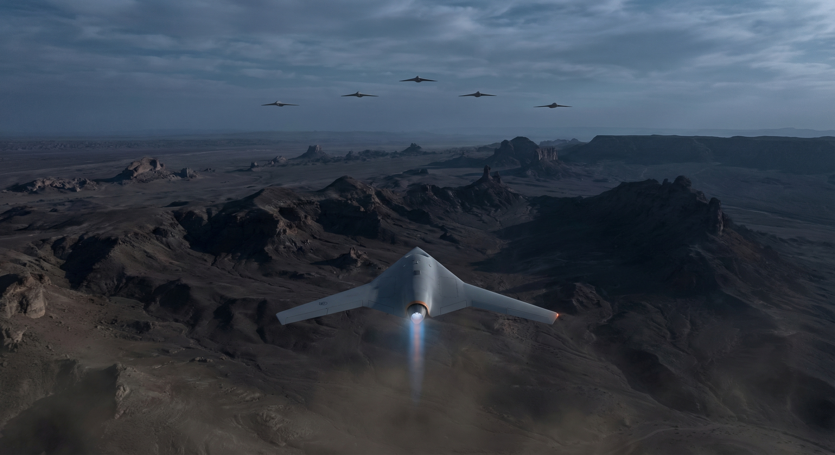 A formation of triangular delta-wing kamikaze drones flying at night over a desert landscape, glowing engine trails visible against a dark sky