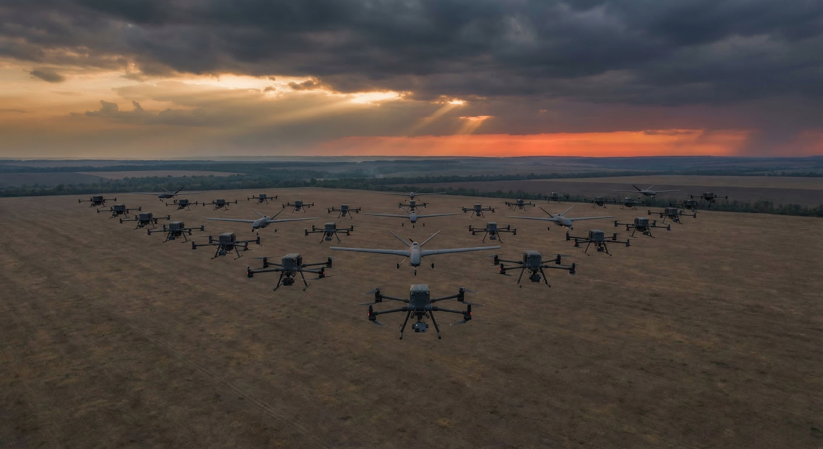 A fleet of military autonomous combat drones flying in formation over a vast steppe landscape at dusk, with a burning orange horizon in the distance